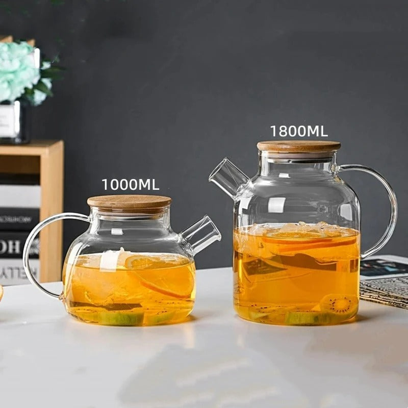 Deux théières en verre avec couvercle en bambou côte à côte, modèles de 1000ml et 1800ml, contenant une infusion aux agrumes