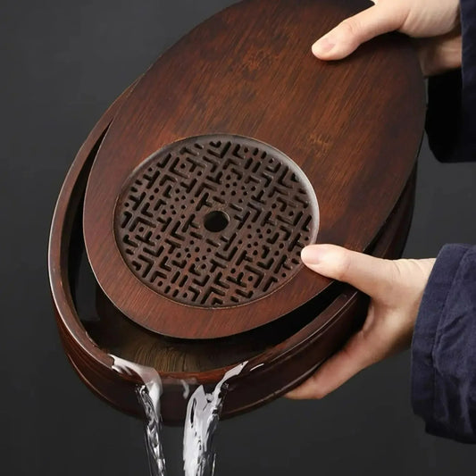 On verse le thé de ce plateau à thé ovale traditionnel