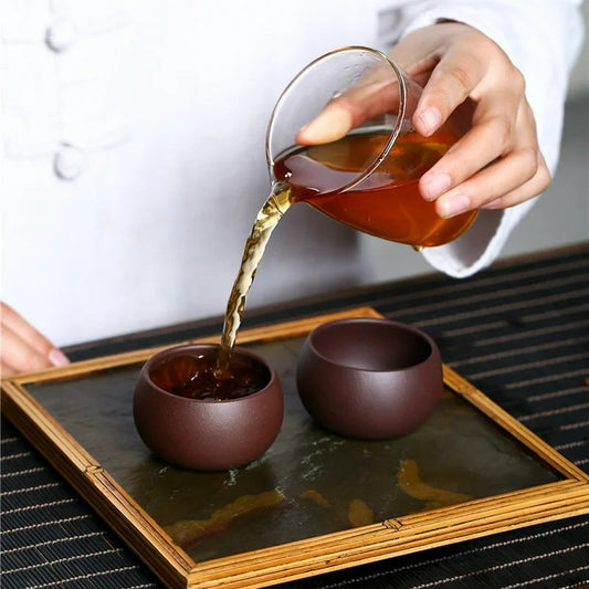 On verse du thé dans nos tasses en céramique pourpre