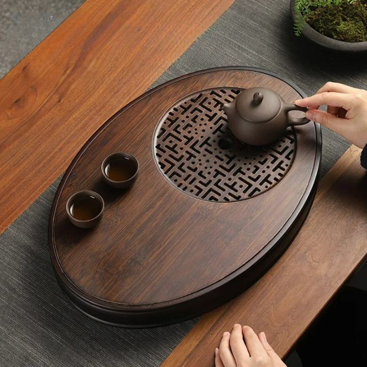 Plateau à thé ovale posé sur une table en bois